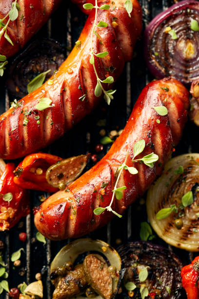 istock Grilled sausages and vegetables with addition spices and fresh herbs 911049144