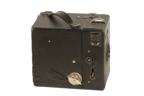 Old fashioned 35mm camera with slide film on bookshelf
