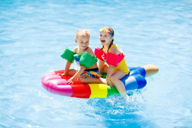 istock Kids on inflatable float in swimming pool. 911073804