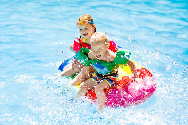 bambini su galleggiante gonfiabile in piscina. - child swimming pool swimming little boys foto e immagini stock