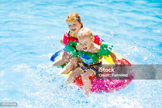 Kids On Inflatable Float In Swimming Pool Stock Photo - Download Image Now - Swimming Pool, Child, Fun