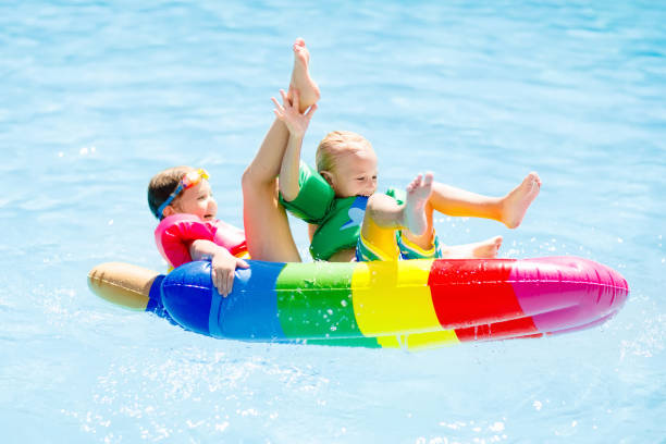 istock Kids on inflatable float in swimming pool. 911074088