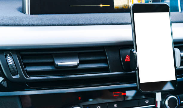 istock Smartphone in a car use for Navigate or GPS. Driving a car with Smartphone in holder. Mobile phone with isolatede white screen. Blank empty screen. copy space. Empty space for text. modern car interior details. 911079392