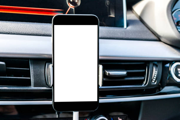 istock Smartphone in a car use for Navigate or GPS. Driving a car with Smartphone in holder. Mobile phone with isolatede white screen. Blank empty screen. copy space. Empty space for text. modern car interior details. 911079538