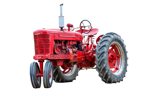 Horizontal shot of an old red work tractor isolated on a white background.