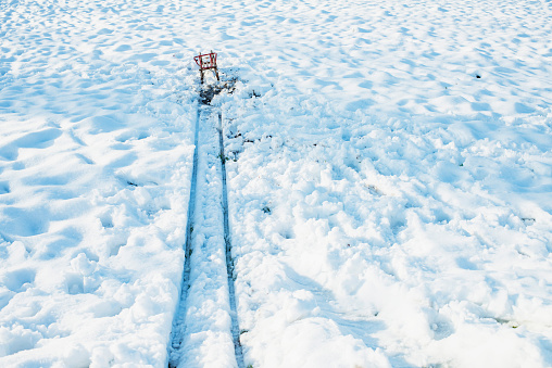 Red sled at the end of track in snow.