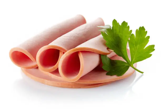 Sliced boiled ham sausage rolls with parsley leaf isolated on white background