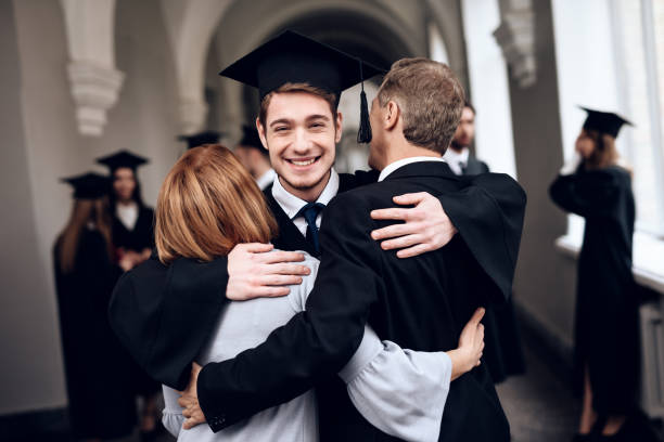 родители поздравляют студента, который заканчивает учебу в университете. - graduation university male student стоковые фото и изображения