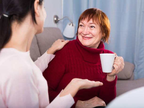 istock Mature woman with daughter talking at sofa 911115452