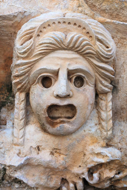 Decorative mask, stone carving, ancient Women's stone theatrical mask carved in stone. Close up. Ancient Lycia, Turkey. greek amphitheater stock pictures, royalty-free photos & images