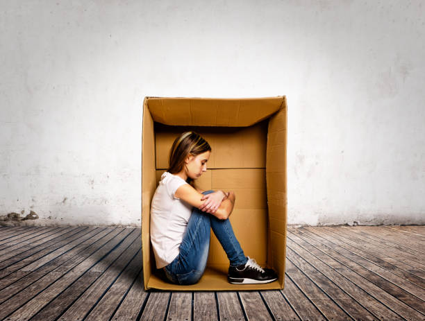 sad young woman inside a Box sad young woman inside a Box on a room pessimism photos stock pictures, royalty-free photos & images