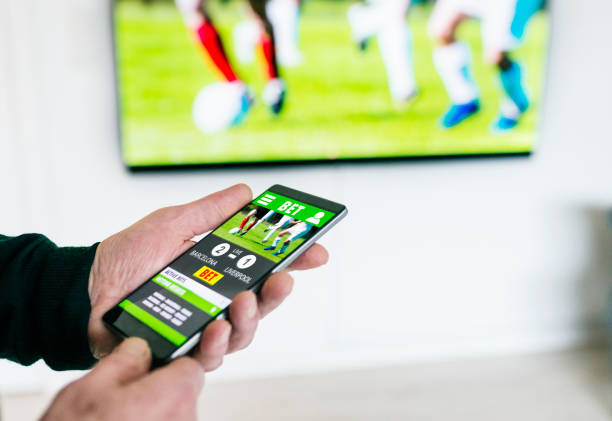 Betting Through Mobile App On Soccer Match Shown In Television Stock Photo  - Download Image Now - iStock