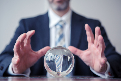 closeup of businessman looking at glass ball on table