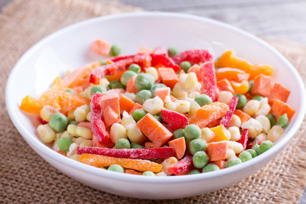 istock Mixed frozen vegetables in a plate on wooden table 911127934