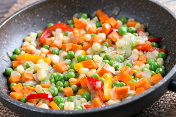Mixed vegetables in a frying pan on wood table, healthy diet food