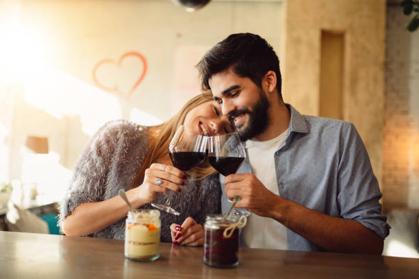 Romantic couple cheers with red wine and celebrating Valentine's day. stock photo