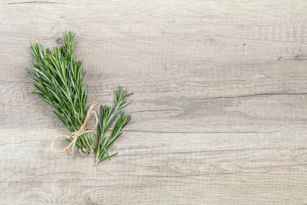 istock Rosemary bunch of bouquets on light wooden surface. Top view, copy space. 911131634