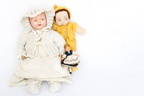 Three antique china and vintage knit dolls together on white background