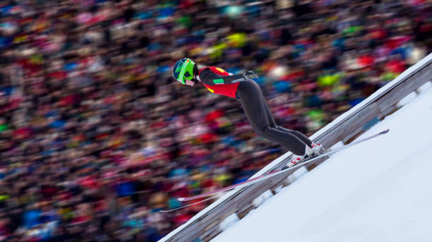 side view of female ski jumper landing - telemark skiing fotos imagens e fotografias de stock