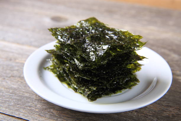 Dried seaweed on white plate Dried seaweed on white plate nori stock pictures, royalty-free photos & images