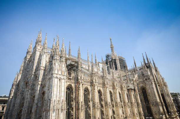 Marble statues of Saints on the spires of the Milan Cathedral Duomo di Milano in Milan Lombardy, Italy Milano Duomo, one of the biggest Gothic style church in the world candoglia marble stock pictures, royalty-free photos & images