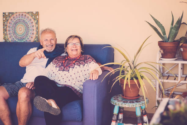 istock happy senior couple sit down on a sofa with plants around 911174782