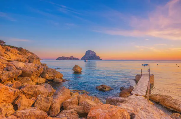 Pier and beautiful landscape at Cala d´Hort on Ibiza at dusk