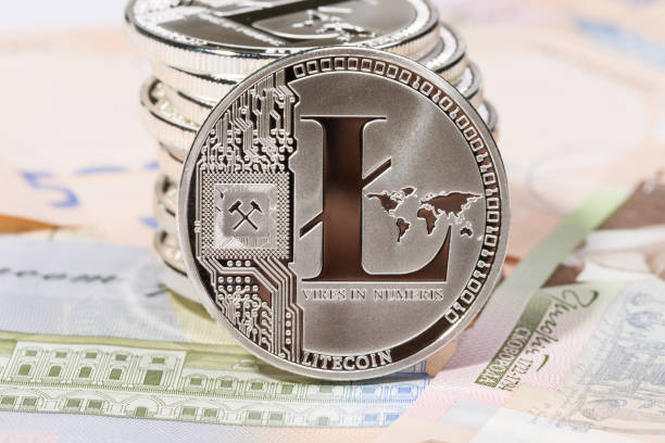 A bunch of litecoins on top of 500 hryvnas background. Litecoin on back side two dollar banknote.  This is souvenir coin that represents real litecoin. Litecoin (LTC)  is a peer-to-peer cryptocurrency and open source software project. Creation and transfer of coins is based on an open source cryptographic protocol and is not managed by any central authority. The coin was inspired by, and in technical details is nearly identical to, Bitcoin (BTC). litecoin stock pictures, royalty-free photos & images