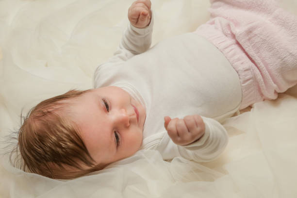 istock Adorable two months old baby wrapped in white fabric 911203482