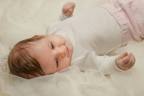 istock Adorable two months old baby wrapped in white fabric 911203562