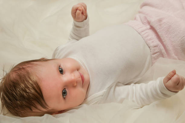 istock Adorable two months old baby wrapped in white fabric 911207814