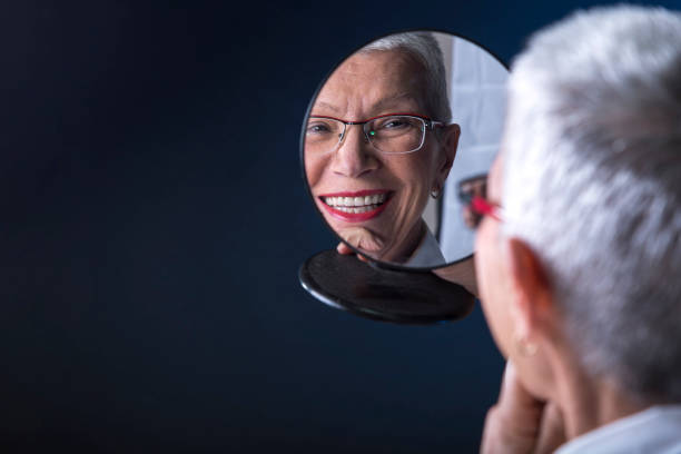 Elderly lady putting make up on