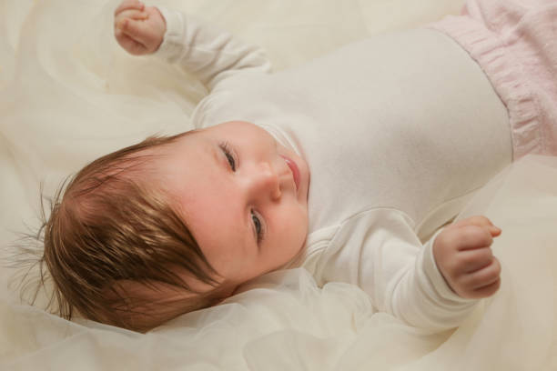 istock Adorable two months old baby wrapped in white fabric 911207950