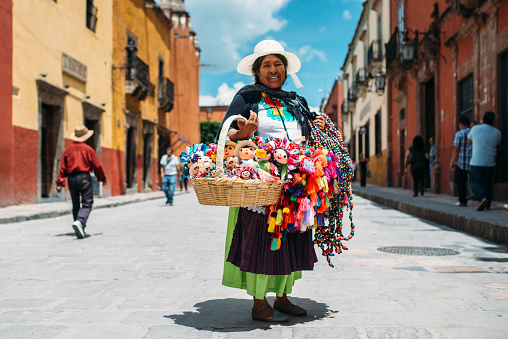 San Miguel de Allende, Guanajuato, Mexico - August 2017: Senior Mexican woman sells hand made traditional Mexican dolls on the streets of San Miguel de Allende.
