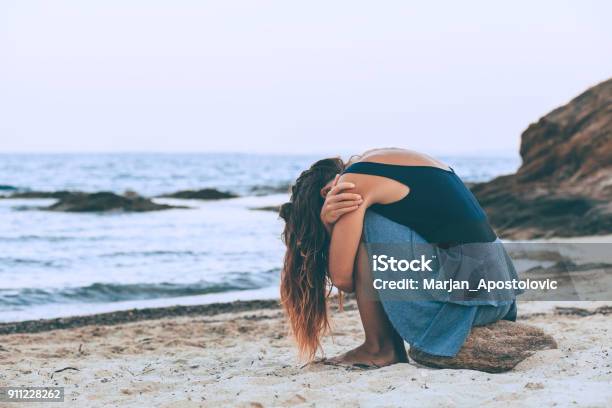 Woman Alone And Depressed Sitting At The Beach Stock Photo - Download Image Now - Illness, Summer, Beach