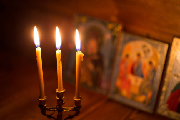 candle against the background of orthodox icons stock photo