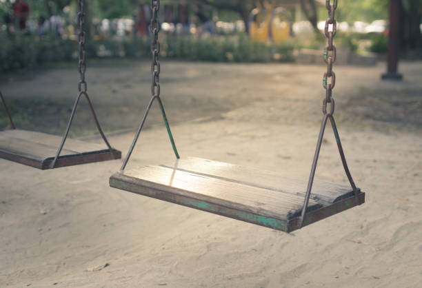 istock Wooden old swings in playground 911246254