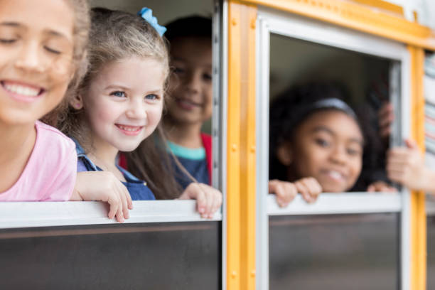 istock School children looking out windows on school bus 911249968