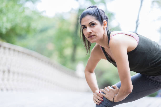 istock Determined woman stretches after workout at park 911250030