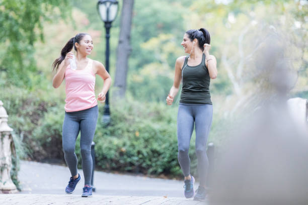 istock Two women enjoy each other's company during a run 911250040