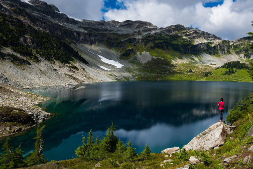 Female hiker visiting a stunning alpine lake