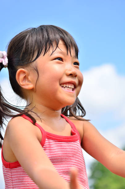 istock Girl's smiling in the blue sky 911267188