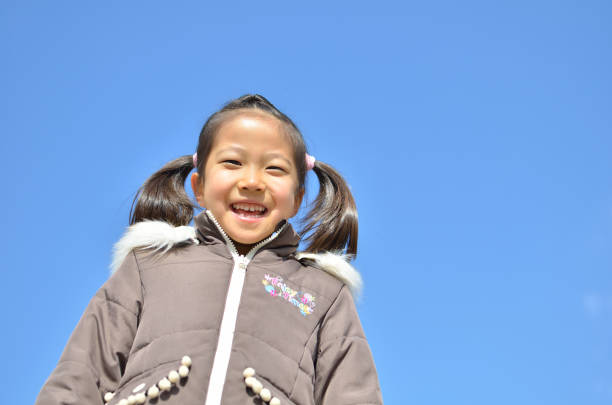 istock Girl's smiling in the blue sky 911267320