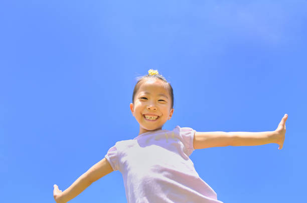 istock Girl's smiling in the blue sky 911270276
