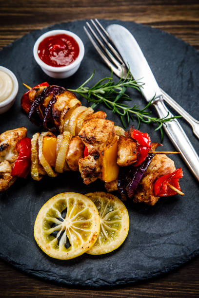 istock Kebabs - grilled meat and vegetables on wooden background 911270288