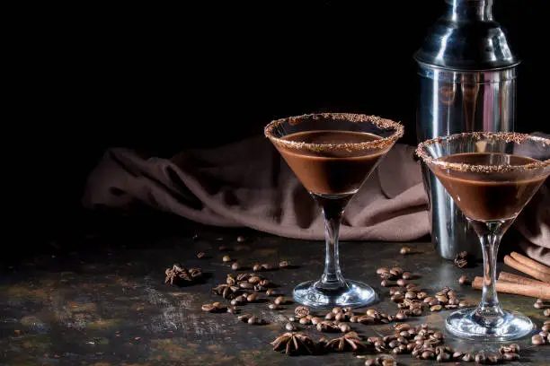 Photo of glasses of cream coffee cocktail or chocolate martini on black background