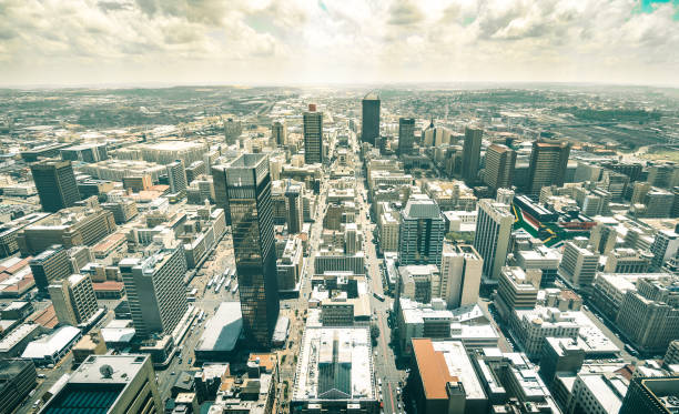 vista aérea de skyline de los rascacielos en el distrito de negocios de johannesburgo - concepto de arquitectura con edificios modernos del horizonte en la ciudad más grande de sudáfrica con la bandera sudafricana en muros de - south africa fotografías e imágenes de stock