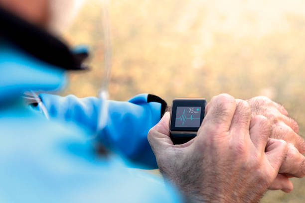 Elderly Man using Smart Watch measuring heart rate during walk