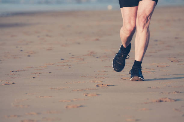 istock Runner legs on the beach during the sunrise. 911282064