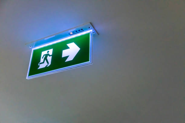 istock Green emergency exit sign. Direction to the escape way on white background. Perspective view 911290856